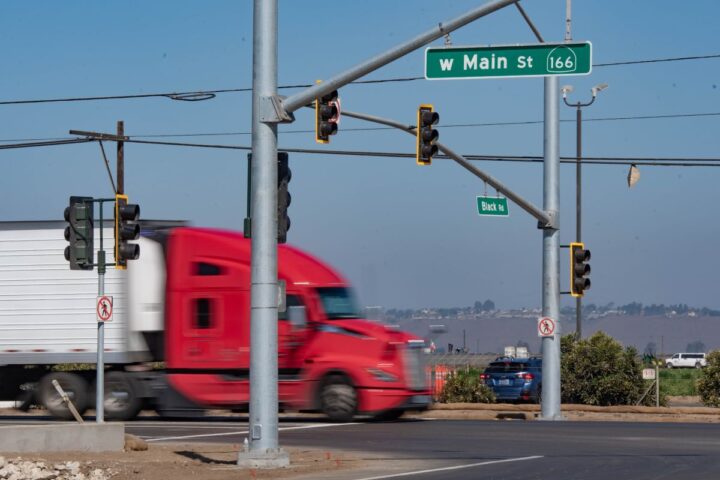 Photo of the Black Road and Main Street Highway 166 intersection with the new traffic signal in operation and a semi truck driving through.