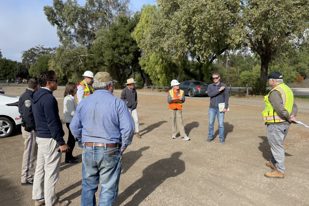 Image of a group comprised of SBCAG, County, CHP and Caltrans staff standing in a circle in a parking lot near State Route 154