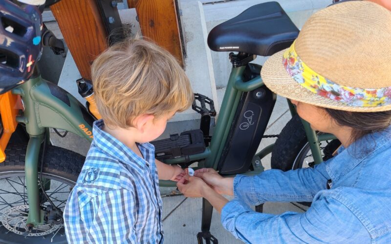 Woman and Son applying a bike registration sticker to an e-bike