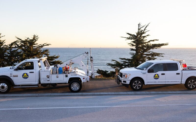 This images shows the freeway service patrol vehicles (tow truck and service truck) against a Pacific Ocean backdrop