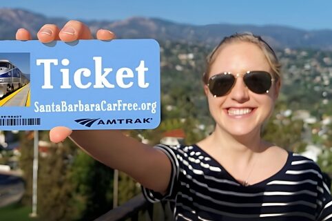 Woman holding an SB Car Free ticket with blurred background of Santa Barbara