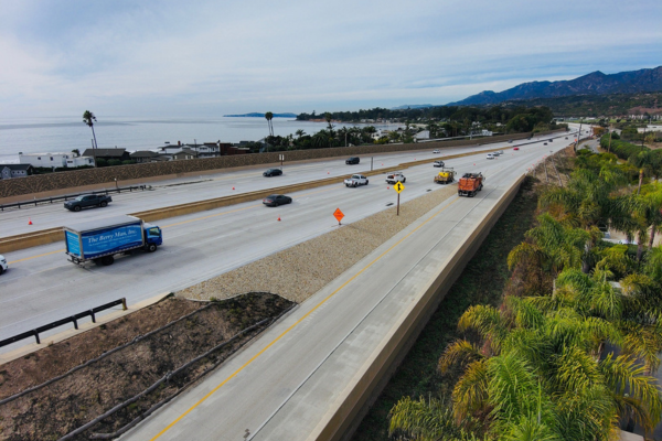 Image of northbound onramp in the Padaro segment of the Highway 101 project looking at construction striping new carpool lanes along a backdrop of oceans and mountains.